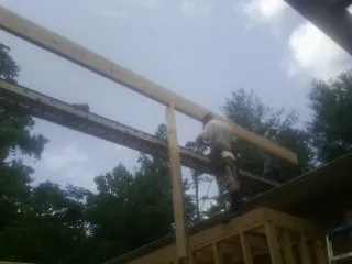 Carpenter setting a ridge beam over a new addition frame — Ice Dam Removal by Roofing Brothers in Weber City