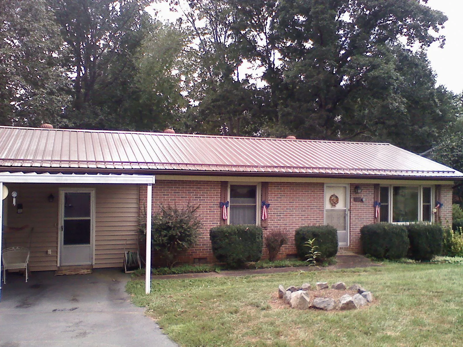 Bronze metal roof and carport on a brick ranch home — Roof Repair work by our crew in Weber City